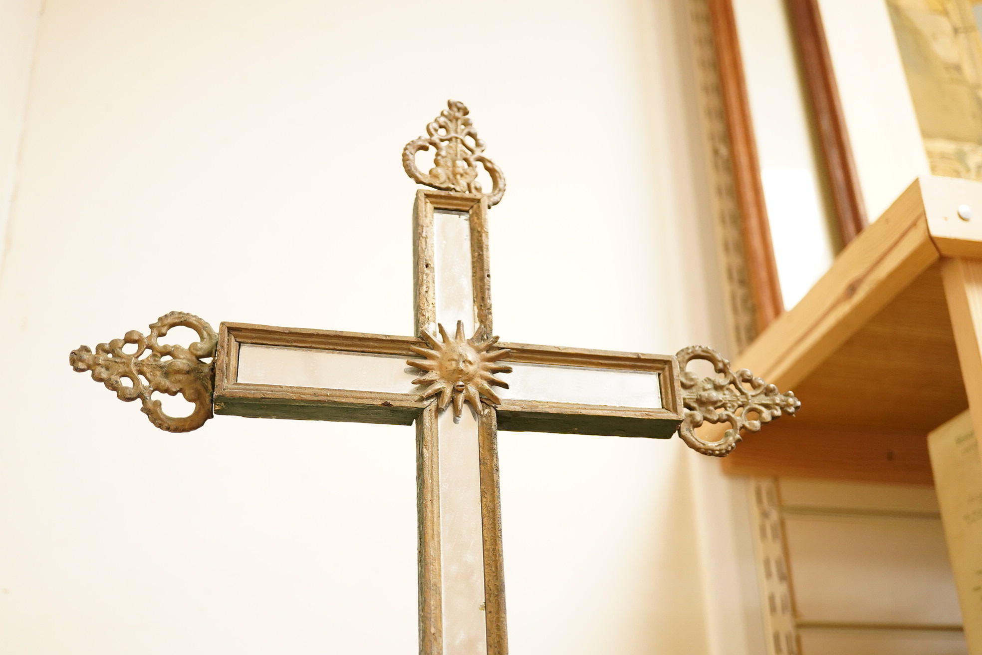 An early 19th century painted pine cross with mirrored front and a cast gilt metal statue of Mary and child, 78cm high